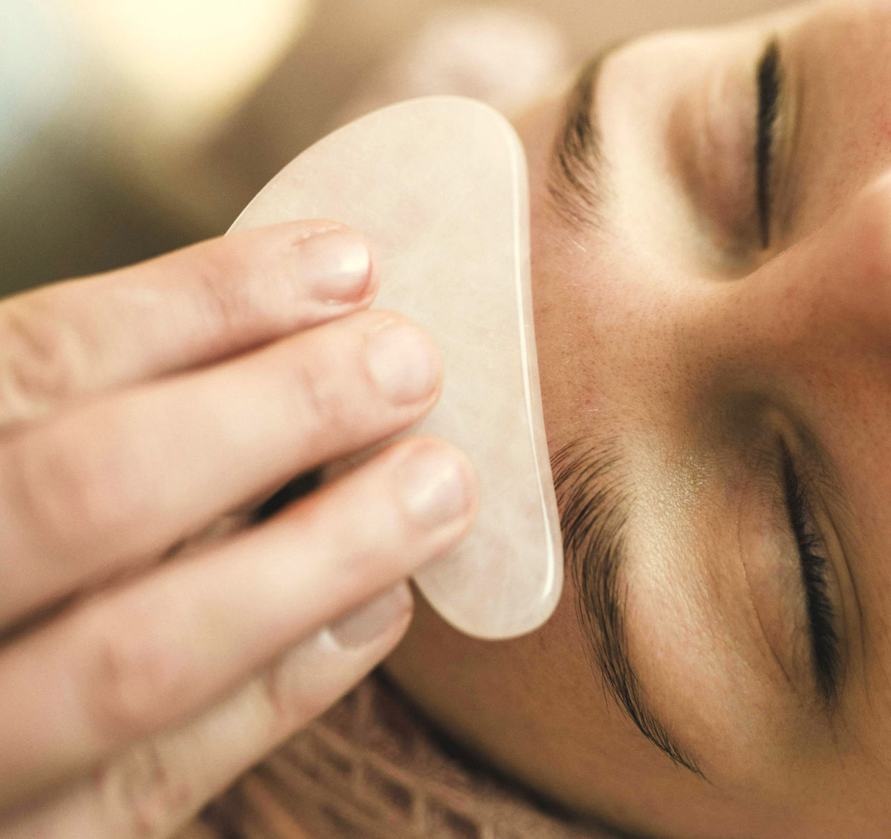 massage gezicht met guasha steen rozenkwarts